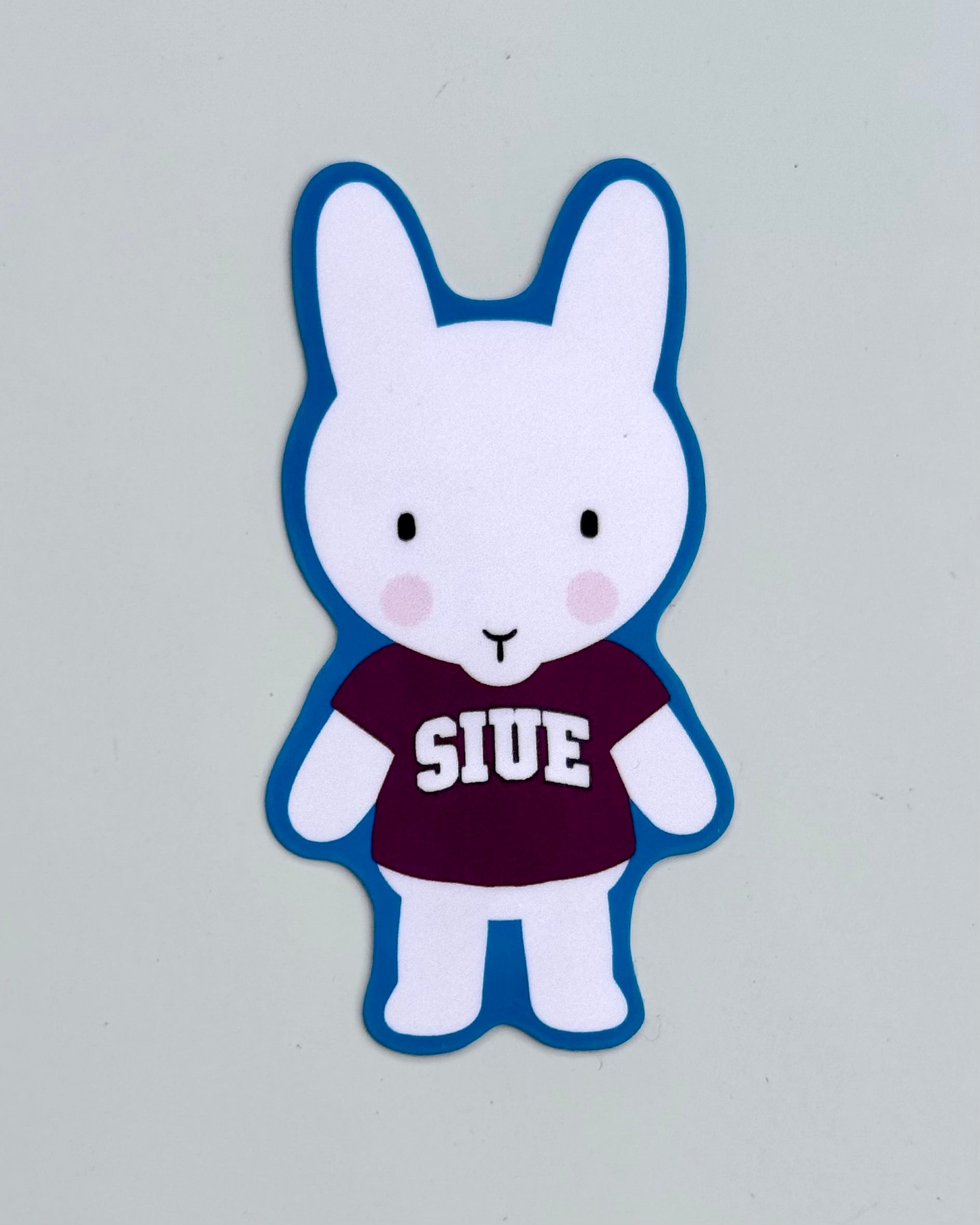 Clem the bun, a white bunny, with a maroon SIUE shirt on.